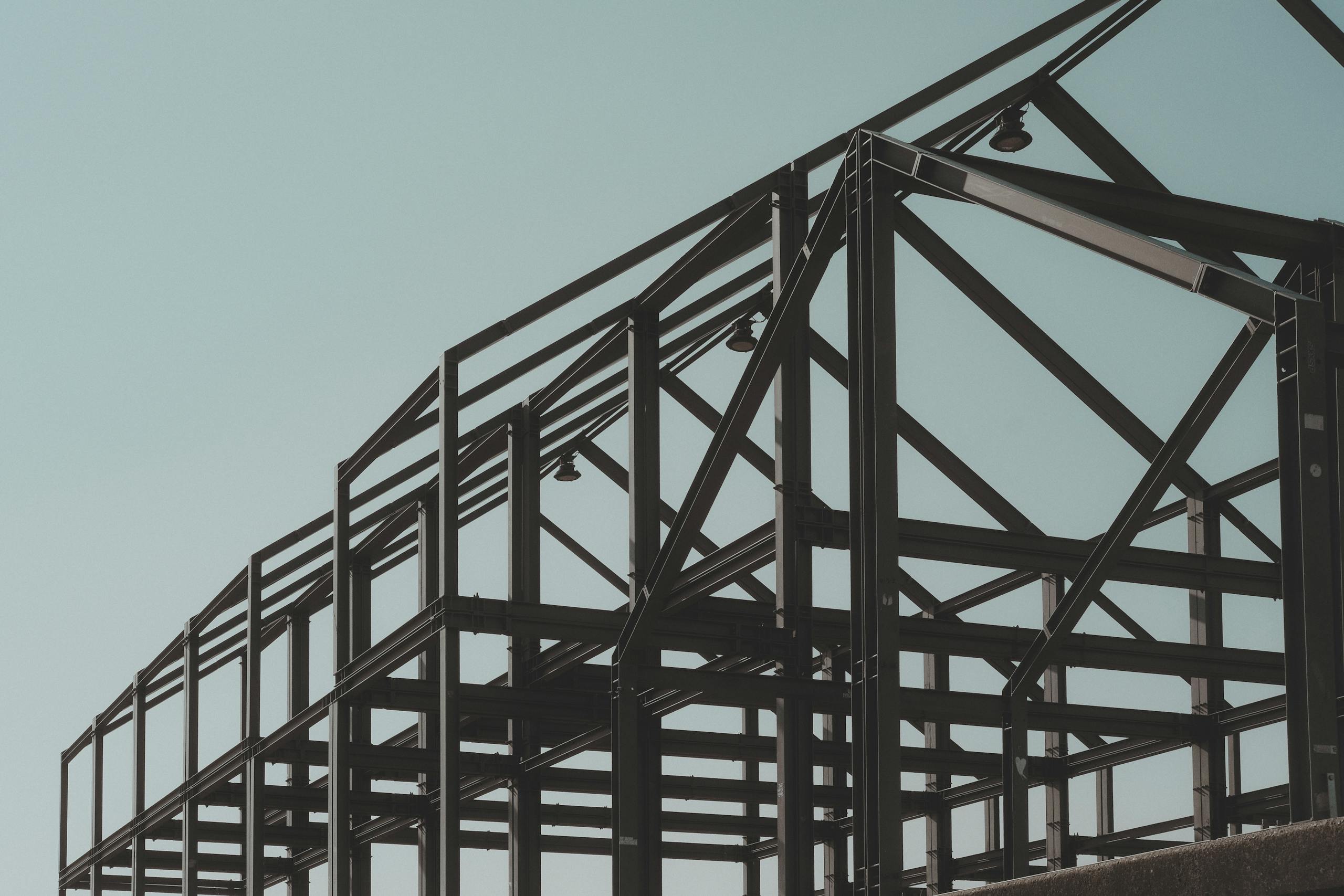 Modern steel framework structure under clear sky, showcasing architectural design.